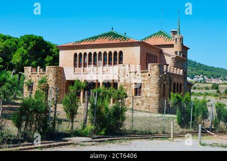 Das Schulgebäude in der Colonia Guell in Santa Coloma de Cervello, Spanien, das im Hintergrund an das Gebäude Casa del Mestre angeschlossen ist, wurde in beiden Gebäuden gebaut Stockfoto