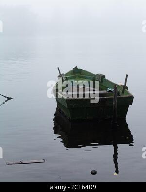 Vertikale Aufnahme eines alten Bootes auf dem See Stockfoto