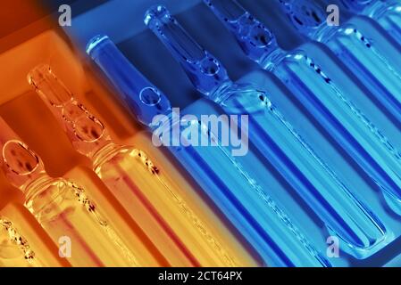 Nahaufnahme der Ampullen-Reihe in der Packung in ultraviolett Beleuchtung mit selektivem roten Gradientenfokus Stockfoto
