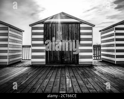 Strandhütte mit Sonnenuntergang von hinten, in Schwarz und Weiß am Hastings Pier Stockfoto