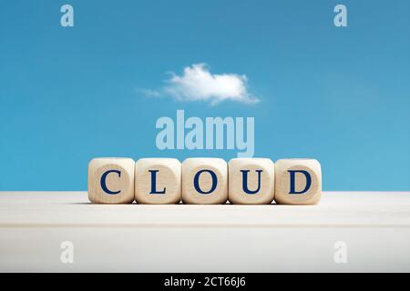 Das Wort Wolke auf Holzblöcken vor einem blauen Himmel und Wolkenhintergrund. Cloud-Computing-Konzept. Stockfoto