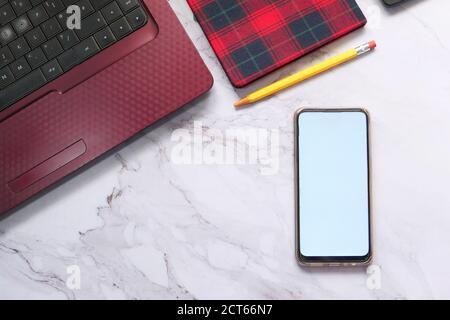 Smartphone mit leerem Bildschirm mit Laptop und Notizblock hintergrund nebeneinander anordnen Stockfoto