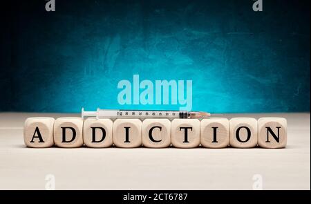 Das Wort sucht auf Holzwürfel mit einer Spritze. Drogen- oder Substanzabhängigkeit Konzept. Stockfoto