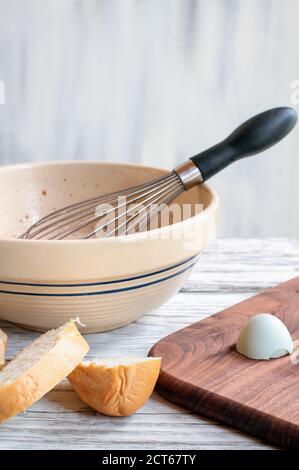 Zutaten für French Toast mit Schneebesen und antiker Schüssel. Bauernhof frische Bio-Eier und ein Laib Brot. Stockfoto