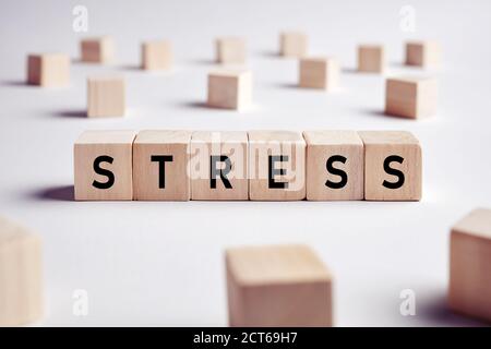 Das Wort Stress auf Holzblöcke auf weißem Hintergrund. Stress am Arbeitsplatz oder im täglichen Leben Konzept. Stockfoto