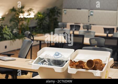 Hintergrundbild von zwei Abfallsortierbehältern für Kunststoff und Karton auf Schreibtisch im modernen Büroinnenraum, Kopierfläche Stockfoto
