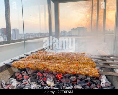 Traditionelle türkische Adana Kebap auf dem Grill mit Spieße zum Abendessen. Türkische Küche Esskultur in der Türkei. Adana Kebab auf dem mangal Stockfoto