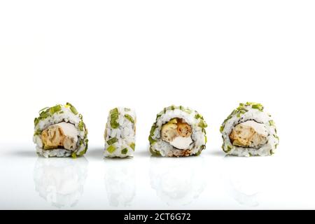 Vier japanische Maki-Sushi-Rollen in einer Reihe mit Frischkäse und Zwiebel isoliert auf weißem Hintergrund.Seitenansicht, Nahaufnahme. Stockfoto