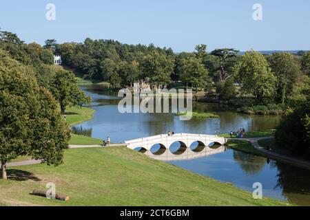 Blick auf den See und einige Torheiten in Painshill Park, einem großartigen englischen Landschaftsgarten aus dem 18. Jahrhundert, Surrey. Stockfoto