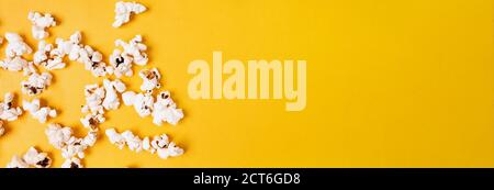 Popcorn auf gelbem Hintergrund gestreut, Draufsicht. Stockfoto