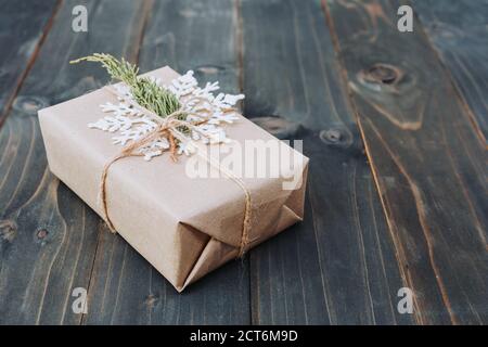 Schnur in einem Bogen auf Kraftpapier gebunden. Beown Geschenkbox auf Holz mit dem Raum. Stockfoto