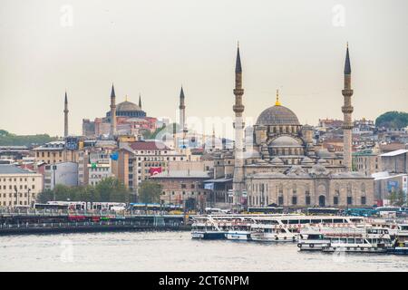 Neue Moschee (Yeni Cami) bei Sonnenuntergang mit Hagia Sophia (Aya Sofya) hinter dem Goldenen Horn, Istanbul, Türkei, Osteuropa Stockfoto