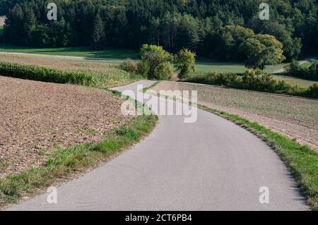 Eine Landstraße in der hügeligen Landschaft des schwäbischen jura in deutschland Stockfoto