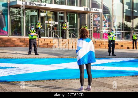 Frau mit schottischer Flagge als Zeichen für Unabhängigkeit protestiert vor dem schottischen Hauptquartier der BBC am Pacific Quay, Glasgow, Schottland, Stockfoto