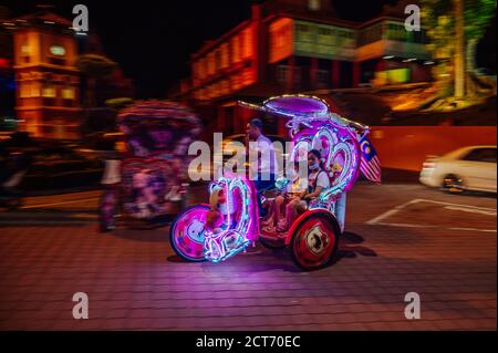 Malacca, Malaysia. September 2020. Touristen fahren auf einem Dreirad in Malacca, Malaysia, 18. September 2020. Obwohl Malacca kein Entrepot mehr ist, zieht es immer noch Touristen aus der ganzen Welt an, da der Tourismus zu einer Säule der lokalen Wirtschaft wird. Die Industrie nahm einen harten Schlag inmitten der Pandemie, aber da Malaysier jetzt innerhalb des Landes reisen können, wird der Ort langsam wieder zum Leben erweckt. UM MIT "Feature: Malaysias alter Entrepot langsam wieder zum Leben, wie der inländische Tourismus nimmt" zu GEHEN.Kredit: Zhu Wei/Xinhua/Alamy Live News Stockfoto