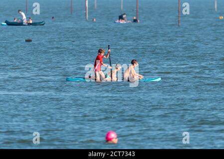 Southend on Sea, Essex, Großbritannien. September 2020. Das Wetter dämmerte neblig und bewölkt in Southend on Sea, brach aber in einen warmen und sonnigen Nachmittag. Die Leute sind draußen und genießen die Nachmittagsflut mit einigen, die zum Wasser gehen. Eine Gruppe Kinder teilen sich ein Paddle Board Stockfoto