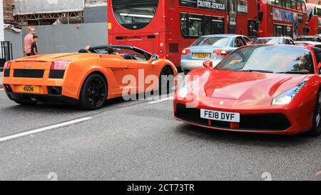 Orange Lamborghini und rot Ferrari. Supercars in Sloane Street für Supercar Sunday, Knightsbridge, London, Großbritannien Stockfoto