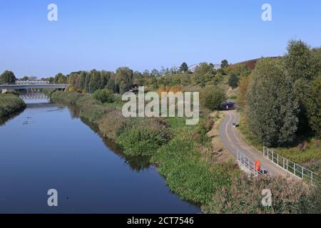 Der Fluss Lea fließt durch den Queen Elizabeth Olympic Park, London. Zeigt reife Landschaft (Sommer 2020). Velodrome und olympische Ringe oben rechts. Stockfoto