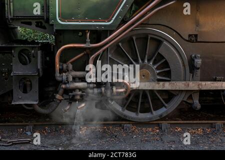 Nahaufnahme Detail der Vintage Dampfmaschine Mechanik. Räder und Fahrwerk mit atmosphärischem Dampf. Schmuddelig und ölig wie Ingenieure. Stockfoto