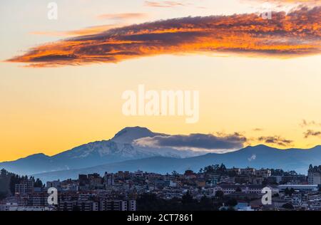 Der Vulkan Cayambe bei Sonnenaufgang mit einem Luftbild von Quito, Anden, Ecuador. Stockfoto