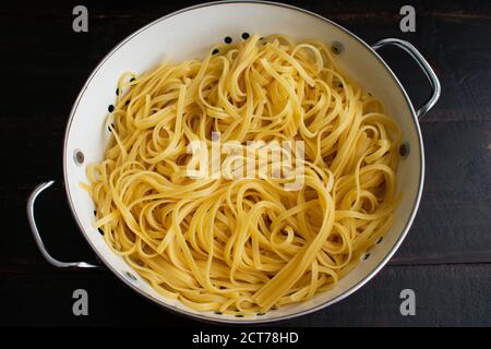 Gekochtes Linguine in einem Sieb abgegossen: Nudeln al dente und in einem Emaille-Sieb abgegossen Stockfoto