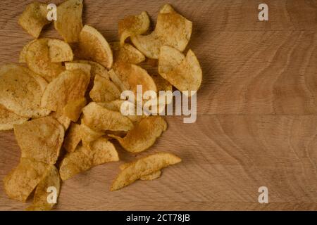 Appetitlich Kartoffelchips, sind auf einem Holzbrett verstreut Stockfoto