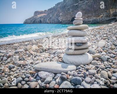 Symbolische Steinschuppen vor dem Hintergrund des Meeres und des blauen Himmels. Konzept von Harmonie und Balance. Vor- und Nachteile Konzept. Platz für Text kopieren. Stockfoto