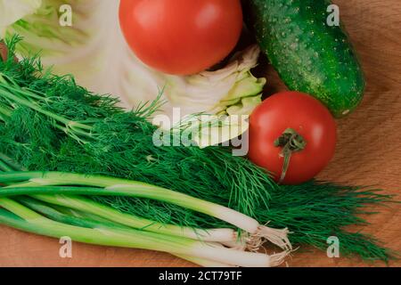 Frisches Gemüse auf einem hölzernen Schneidebrett Dillkohl, Zwiebelgurken Tomate Stockfoto