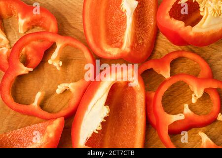 Geschnittene Stücke, Teile, Lappen von Paprika, rot, auf einem Holzbrett Stockfoto