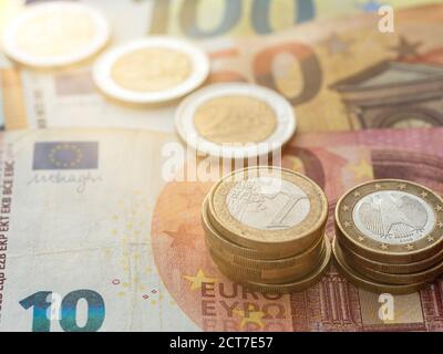 Nahaufnahme der Euro-Münzstapel auf Euro-Scheinen. Stockfoto