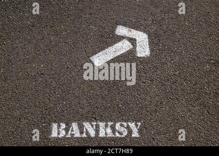 Ein Schild, das auf einem Bürgersteig gesprüht wurde, führt die Besucher zur Kunstausstellung von Banksy Dismaland in Weston-super-Mare, Großbritannien, am 6. September 2015 Stockfoto