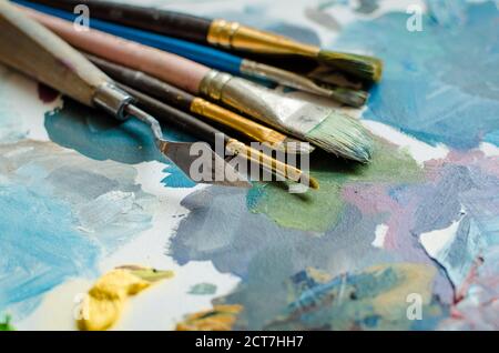 Künstler Pinsel auf Holz- Palette. Textur gemischt Ölfarben in verschiedenen Farben. Instrumente Werkzeuge für kreative Freizeit. Malerei hobby backgroun Stockfoto