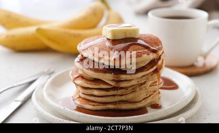 Pfannkuchen mit Butter und Ahornsirup auf einem Teller. Leckeres, süßes Frühstück Stockfoto