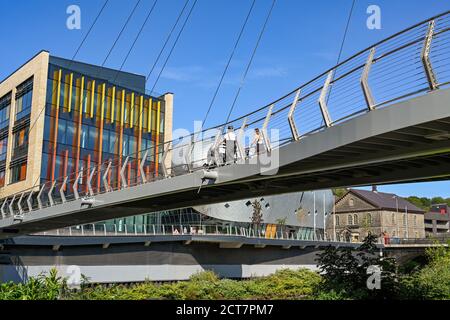 Pontypridd, Wales - September 2020: Menschen, die über die Fußgängerbrücke über den Fluss Taff zu Büros in der neuen Taff Vale Entwicklung in Pontypridd gehen Stockfoto