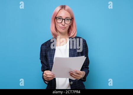 Porträt der jungen schönen Geschäftsfrau Lesen von Dokumenten in blau Hintergrund Stockfoto