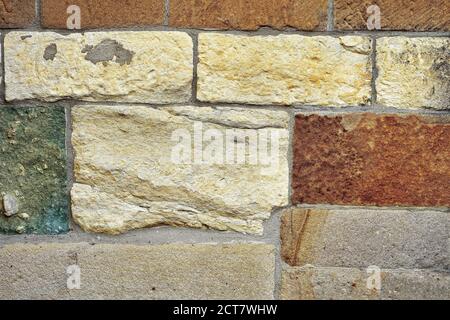 Bunte Hauswand aus Sandsteinziegeln. Natürlicher Texturhintergrund. Stockfoto