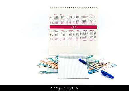 Blauer Stift und Kalender 2021, leeres Blatt und Kalender 2021 auf weißem Hintergrund, russisches Geld und Notizblock Stockfoto
