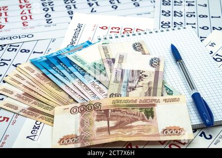 Ein blauer Stift und russische Banknoten, ein sauberes Blatt und ein blauer Stift, russisches Geld und ein Notizblock Stockfoto