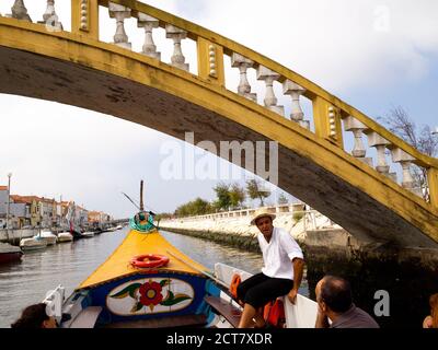 Traditionelles Moliceiro-Touristenboot, das über die Carcavelos-Brücke auf dem Kanal Sao Roque, Aveiro, Portugal, fährt Stockfoto