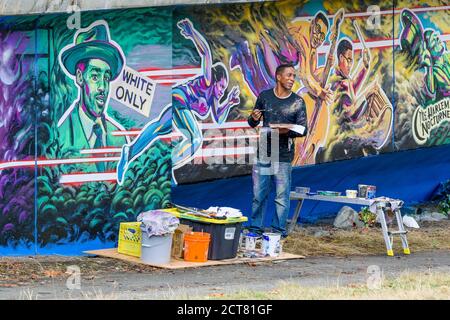 Der Künstler Anthony Joseph malt Hogan's Alley, Black History Wandgemälde auf dem Dunsmuir Viaduct, Vancouver, British Columbia, Kanada Stockfoto