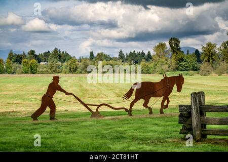 Rosty Metal Art Installation, Farmer mit Pferdepflug, Derby Reach Regional Park, Langley, British Columbia, Kanada Stockfoto