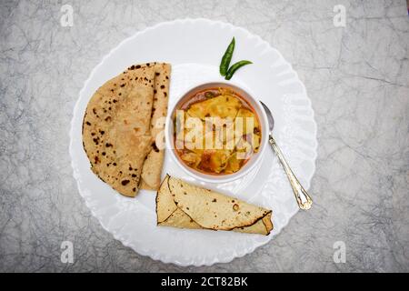 Papad KI sabji in einer Schüssel serviert mit Roti und gerollten Pappadam und grün kühl in Teller Schüssel Löffel. Traditionelles indisches Essen zum Mittag- oder Abendessen Stockfoto