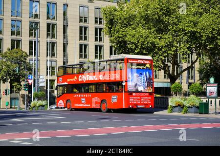 Rote Doppeldecker-Stadtrundfahrt 'Hop on / Hop off'-Bus wartet an einer Haltestelle in der Königsallee in Düsseldorf, Deutschland. Stockfoto