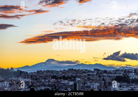 Sonnenaufgang in großer Höhe in Quito Stadt mit der schneebedeckten Cayambe Vulkan Silhouette, Ecuador. Stockfoto