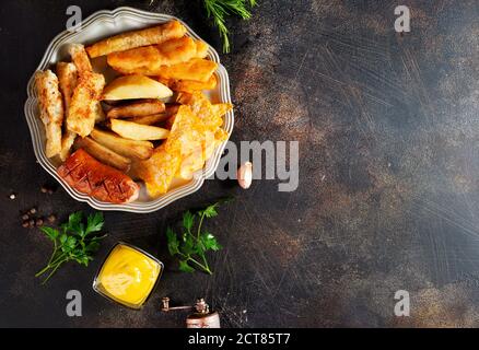 Gebratene Wurst Kartoffel Fisch Filet und Nachos Stockfoto