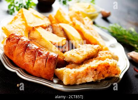 Gebratene Wurst Kartoffel Fisch Filet und Nachos Stockfoto