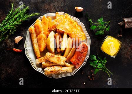 Gebratene Wurst Kartoffel Fisch Filet und Nachos Stockfoto