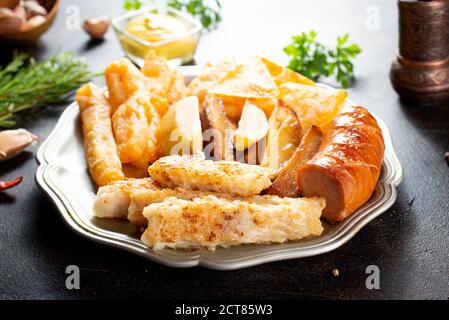 Gebratene Wurst Kartoffel Fisch Filet und Nachos Stockfoto