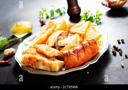 Gebratene Wurst Kartoffel Fisch Filet und Nachos Stockfoto