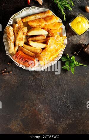 Gebratene Wurst Kartoffel Fisch Filet und Nachos Stockfoto